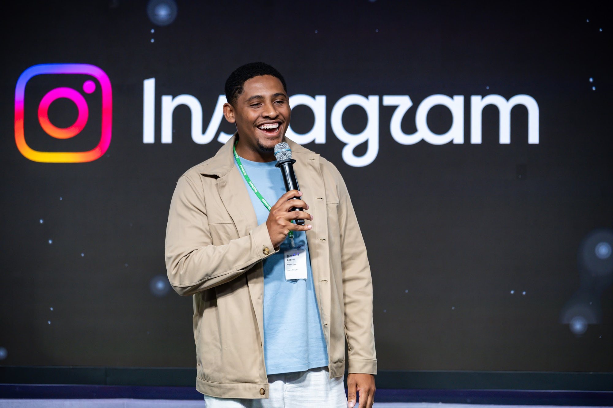 Gabriel Vital sorrindo no palco do Instagram durante o Meta Day by Pareto, no escritório da Meta em São Paulo